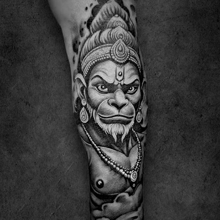 Tattoo of the Hindu deity Hanuman, showcasing detailed facial features and elaborate jewelry, designed at a tattoo shop in Kolkata