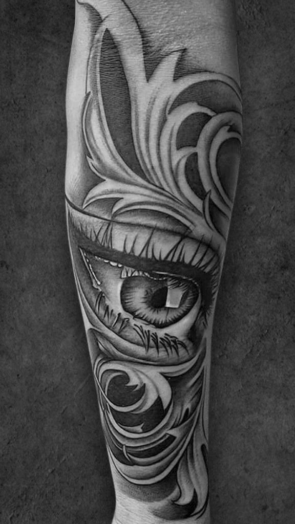 Black and grey forearm tattoo depicting a realistic eye amid abstract swirls, designed at a tattoo shop in Kolkata